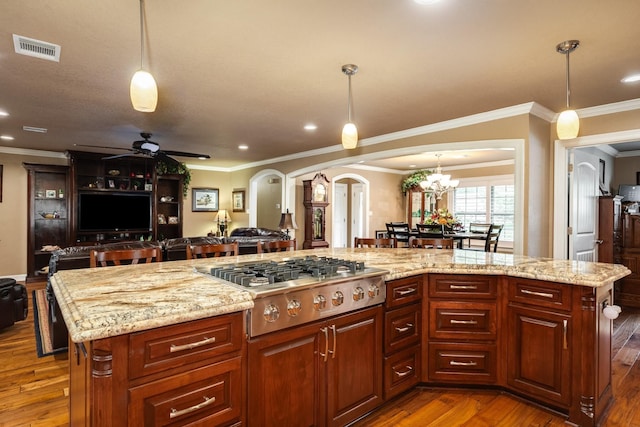 116 Cardinal St, Lake Jackson, TX 77566 - kitchen featuring stainless steel gas stovetop, arched walkways, open floor plan, a ceiling fan, and dark wood finished floors