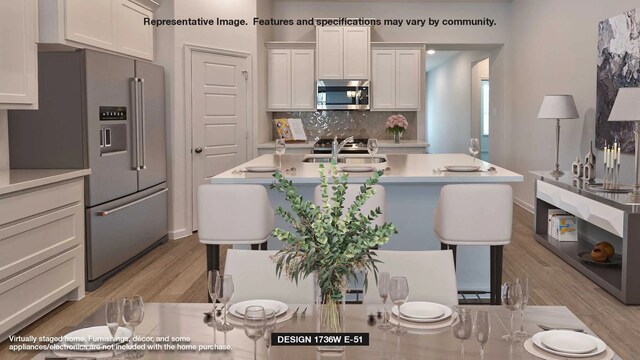 4638 Hydra Ln, Richmond, TX 77469 - kitchen with appliances with stainless steel finishes, light wood-style floors, backsplash, and light countertops