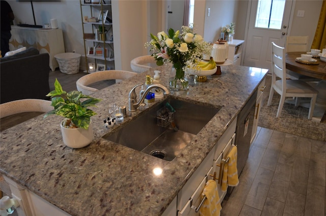 11711 Colossal Oak Dr, Houston, TX 77066 - kitchen featuring light stone counters, wood finished floors, dishwasher, and white cabinets