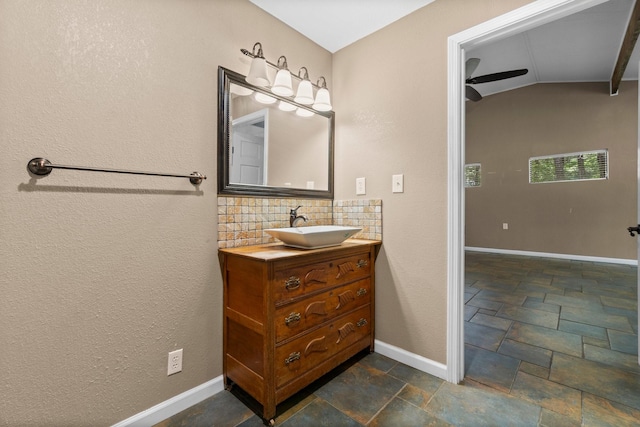 2540 Howell Rd, Corrigan, TX 75939 - bathroom featuring vanity, stone tile floors, tasteful backsplash, and vaulted ceiling