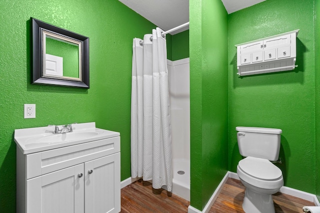 2540 Howell Rd, Corrigan, TX 75939 - full bath featuring wood finished floors, vanity, a shower stall, and a textured wall