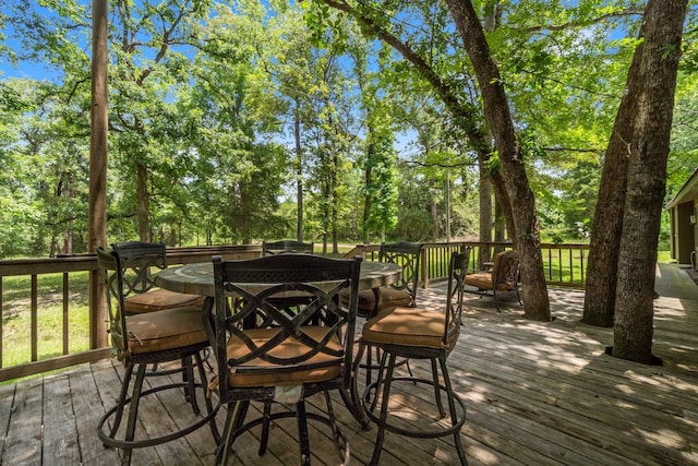 2540 Howell Rd, Corrigan, TX 75939 - wooden deck featuring outdoor dining space and view of wooded area