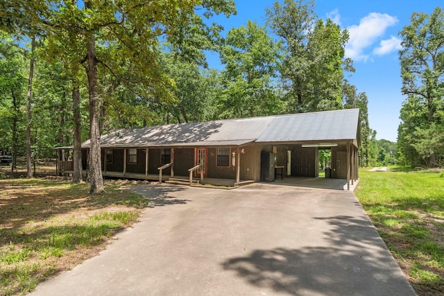 2540 Howell Rd, Corrigan, TX 75939 - view of front of property with asphalt driveway, a porch, a metal roof, and a carport
