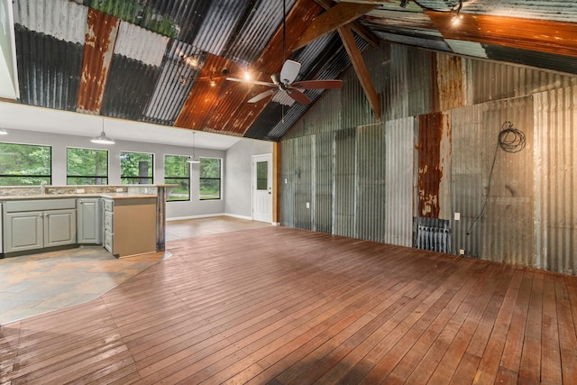 2540 Howell Rd, Corrigan, TX 75939 - unfurnished living room with high vaulted ceiling, light wood-type flooring, wooden walls, and ceiling fan