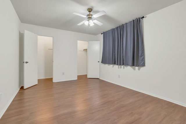 9403 Pinole Ln, Houston, TX 77086 - unfurnished bedroom featuring wood finished floors, ceiling fan, a walk in closet, and a closet