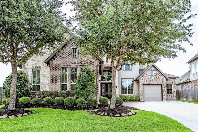 10318 Easterly Ln, Cypress, TX 77433 - view of front facade featuring driveway, brick siding, an attached garage, and stone siding