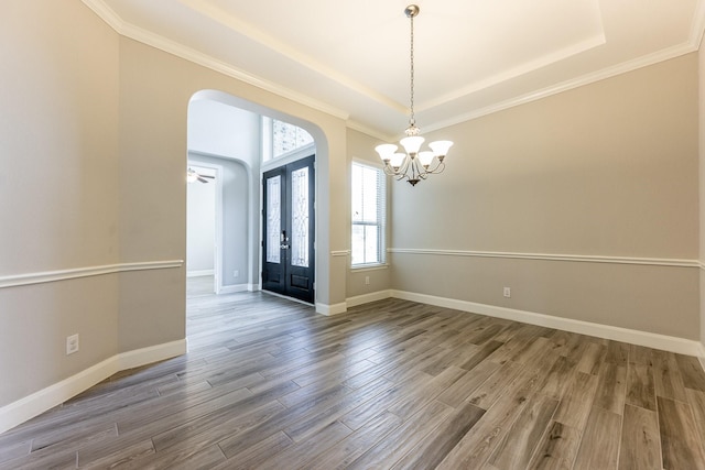 10318 Easterly Ln, Cypress, TX 77433 - entryway with arched walkways, a chandelier, wood finished floors, a tray ceiling, and ornamental molding