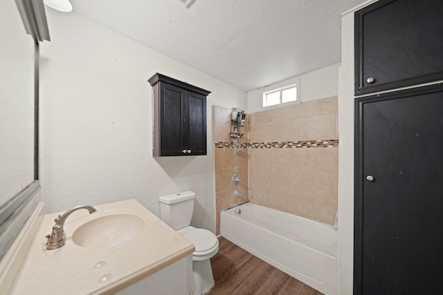 606 W 7th St, Freeport, TX 77541 - full bathroom with wood finished floors, vanity, bathing tub / shower combination, and a textured ceiling