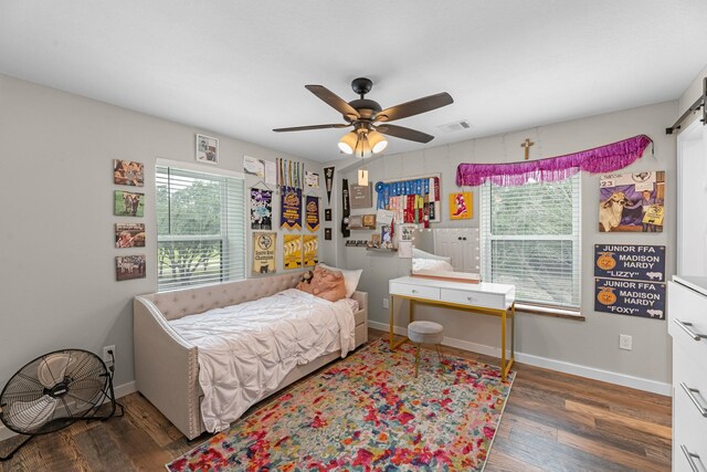 4439 W Bayshore Rd, Anahuac, TX 77514 - bedroom with wood finished floors, ceiling fan, and a barn door