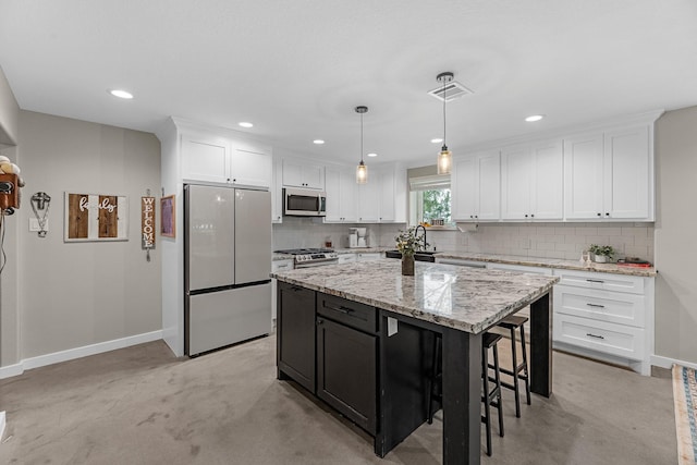 4439 W Bayshore Rd, Anahuac, TX 77514 - kitchen featuring appliances with stainless steel finishes, white cabinets, backsplash, and recessed lighting