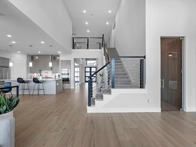 11319 Flying Admiral Dr, Cypress, TX 77433 - stairs with wood finished floors, a towering ceiling, and recessed lighting