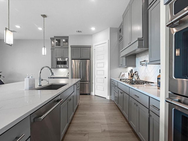 11319 Flying Admiral Dr, Cypress, TX 77433 - kitchen featuring appliances with stainless steel finishes, gray cabinets, backsplash, glass insert cabinets, and recessed lighting