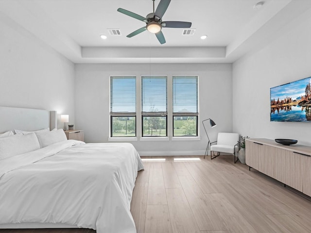 11319 Flying Admiral Dr, Cypress, TX 77433 - bedroom featuring a raised ceiling, light wood-style floors, and a ceiling fan