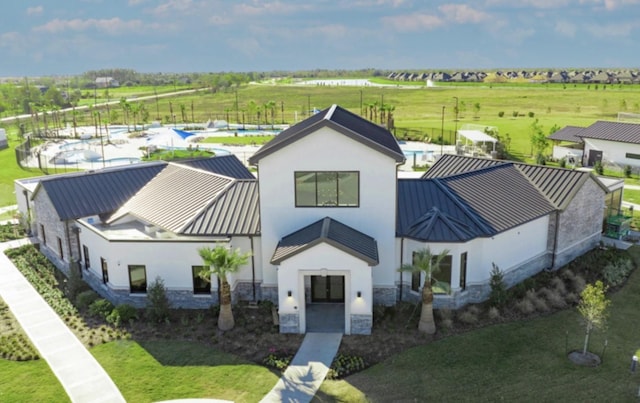 1314 Ponderosa Pine Dr, Rosharon, TX 77583 - modern home featuring a standing seam roof, stone siding, a metal roof, and stucco siding