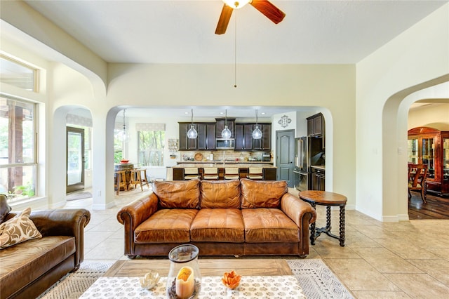 7003 Fall Creek Ln, Missouri City, TX 77459 - living area with arched walkways, healthy amount of natural light, a ceiling fan, and light tile patterned floors
