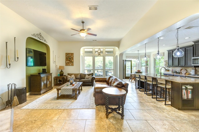 7003 Fall Creek Ln, Missouri City, TX 77459 - living area featuring ceiling fan, arched walkways, and a chandelier