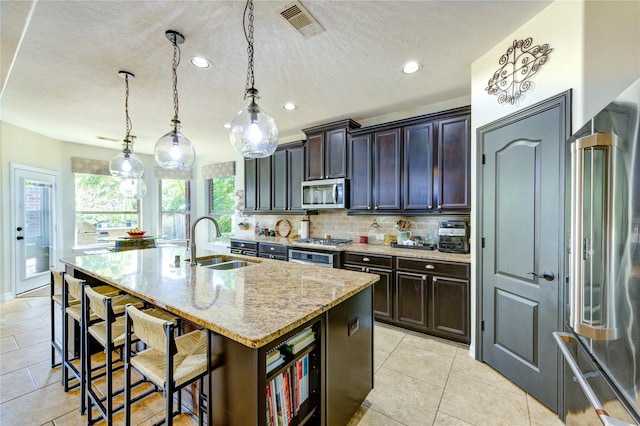 7003 Fall Creek Ln, Missouri City, TX 77459 - kitchen featuring appliances with stainless steel finishes, light tile patterned flooring, light stone counters, decorative backsplash, and recessed lighting