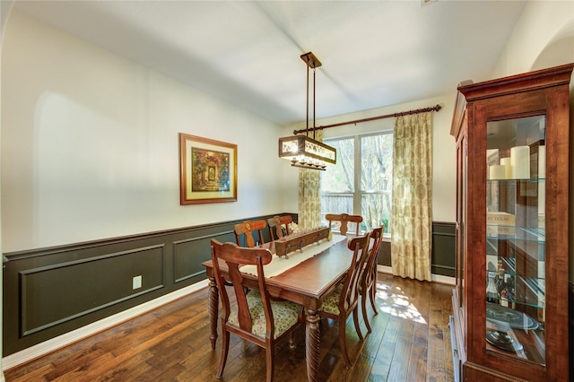 7003 Fall Creek Ln, Missouri City, TX 77459 - dining space featuring dark wood-type flooring, a wainscoted wall, a decorative wall, and a chandelier