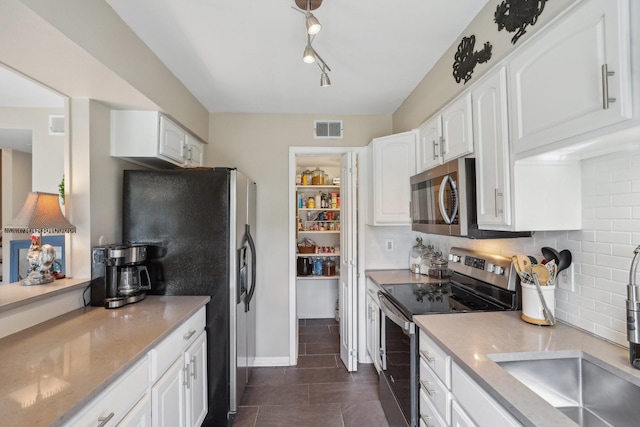 6355 Del Monte Dr Unit 64, Houston, TX 77057 - kitchen featuring stainless steel appliances, tasteful backsplash, and white cabinetry