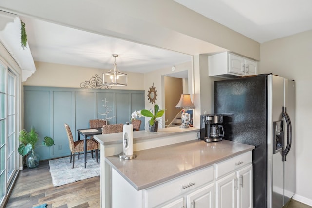 6355 Del Monte Dr Unit 64, Houston, TX 77057 - kitchen featuring refrigerator with ice dispenser, light wood-style flooring, white cabinetry, and pendant lighting