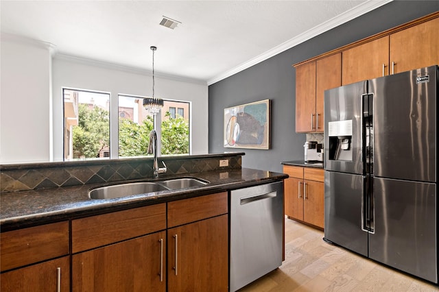 5223 Eigel St, Houston, TX 77007 - kitchen featuring appliances with stainless steel finishes, backsplash, light wood-style floors, brown cabinetry, and ornamental molding