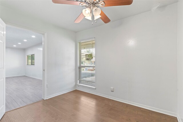 10906 Keese Dr, Houston, TX 77089 - empty room with healthy amount of natural light, wood finished floors, ceiling fan, and recessed lighting