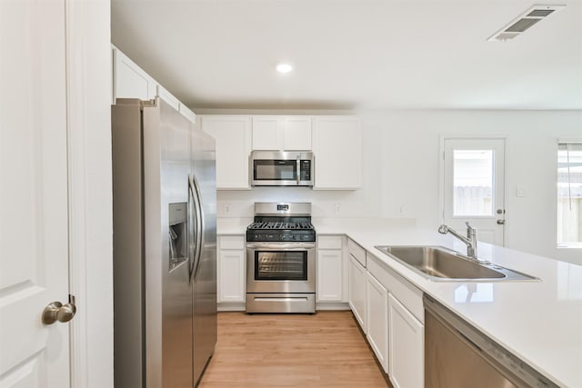 17427 Cyprian Cedar Ln, New Caney, TX 77357 - kitchen featuring stainless steel appliances, light countertops, white cabinets, and recessed lighting