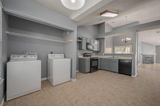 7770 Pine Center Dr, Houston, TX 77095 - laundry room featuring washing machine and clothes dryer, a textured ceiling, a chandelier, and light tile patterned floors