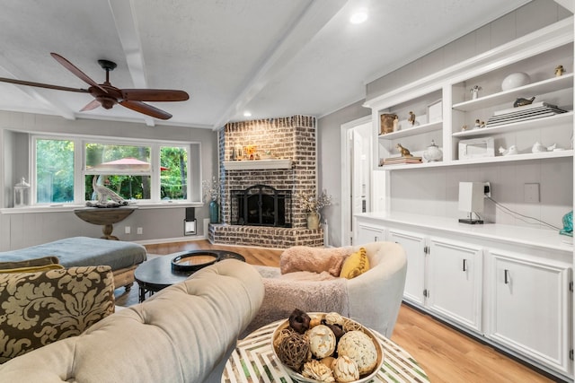 24111 Norchester Way, Spring, TX 77389 - living area with light wood finished floors, beamed ceiling, a ceiling fan, and a fireplace