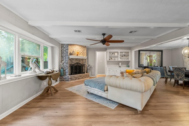 24111 Norchester Way, Spring, TX 77389 - living room with beam ceiling, a brick fireplace, light wood-style floors, and ceiling fan