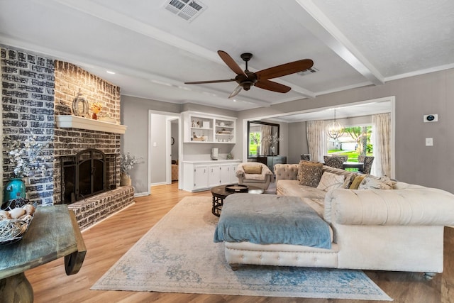 24111 Norchester Way, Spring, TX 77389 - living room featuring ceiling fan, a brick fireplace, beamed ceiling, light wood-style floors, and a chandelier