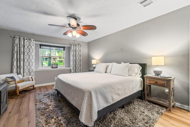 24111 Norchester Way, Spring, TX 77389 - bedroom with wood finished floors, ceiling fan, and a textured ceiling