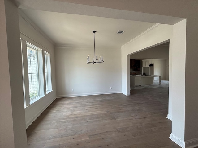 6560 Brayfield, Beaumont, TX 77706 - unfurnished dining area with crown molding, wood finished floors, and a chandelier