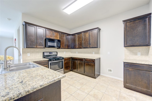 9207 Ranch Ridge Ln, Richmond, TX 77407 - kitchen featuring black microwave, stainless steel gas stove, dark brown cabinetry, backsplash, and light tile patterned floors