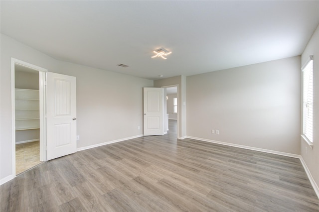 9207 Ranch Ridge Ln, Richmond, TX 77407 - unfurnished bedroom with wood finished floors, multiple windows, and a spacious closet