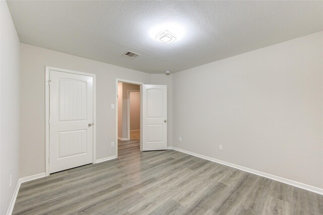 9207 Ranch Ridge Ln, Richmond, TX 77407 - unfurnished bedroom featuring light wood finished floors and a textured ceiling