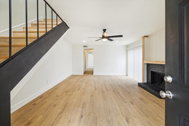 7822 Pacific Pearl St, Houston, TX 77072 - unfurnished living room featuring a ceiling fan, a brick fireplace, light wood-style flooring, stairs, and recessed lighting