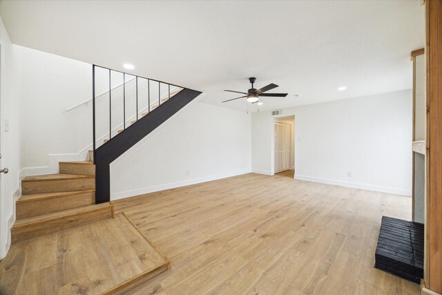 7822 Pacific Pearl St, Houston, TX 77072 - unfurnished living room featuring ceiling fan, stairway, light wood-style floors, and recessed lighting