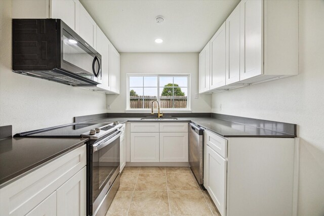7822 Pacific Pearl St, Houston, TX 77072 - kitchen featuring appliances with stainless steel finishes, dark countertops, white cabinets, and recessed lighting