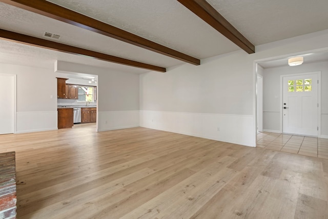 6515 Pebble Beach Dr, Houston, TX 77069 - unfurnished living room featuring light wood-style floors, beam ceiling, a wainscoted wall, and healthy amount of natural light