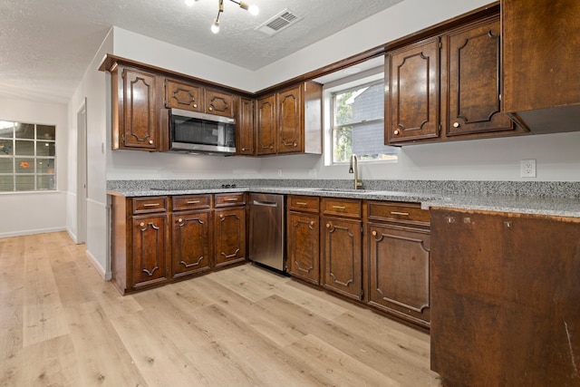 6515 Pebble Beach Dr, Houston, TX 77069 - kitchen with stainless steel appliances, light wood-type flooring, a textured ceiling, and dark brown cabinetry