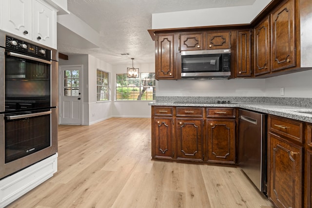 6515 Pebble Beach Dr, Houston, TX 77069 - kitchen featuring stainless steel appliances, light wood-style floors, a chandelier, a textured ceiling, and dark brown cabinetry