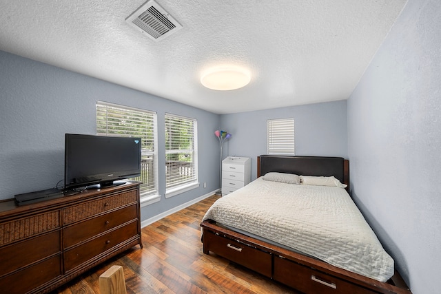 1305 Fairview Dr, Alvin, TX 77511 - bedroom with dark wood finished floors, a textured ceiling, and a textured wall