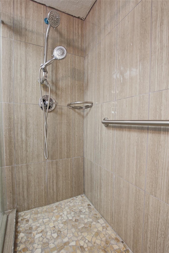 1305 Fairview Dr, Alvin, TX 77511 - bathroom featuring a tile shower and stone finish floors