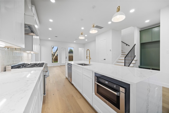 8646 Alcott Dr, Houston, TX 77080 - kitchen with appliances with stainless steel finishes, light wood-style flooring, premium range hood, backsplash, and white cabinetry