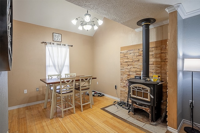 541 N Village Creek Pkwy, Lumberton, TX 77657 - dining room with light wood-type flooring, a wood stove, vaulted ceiling, a chandelier, and a textured ceiling