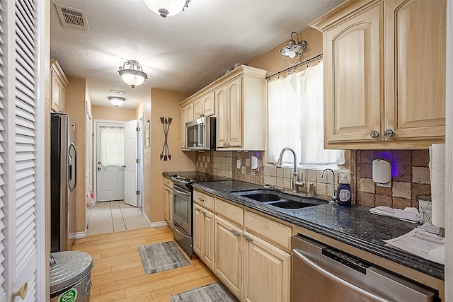 541 N Village Creek Pkwy, Lumberton, TX 77657 - kitchen with stainless steel appliances, light brown cabinets, light wood-style flooring, tasteful backsplash, and a textured ceiling