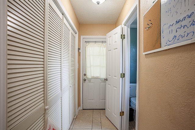 541 N Village Creek Pkwy, Lumberton, TX 77657 - hallway with a textured ceiling, light tile patterned flooring, and a textured wall