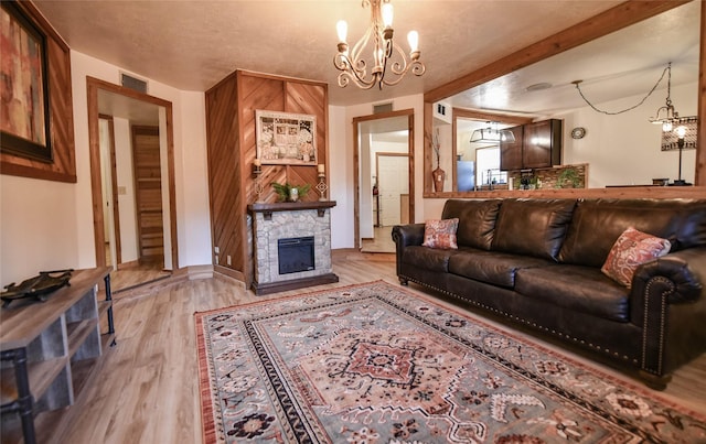 507 W Fawn St, Caldwell, TX 77836 - living area featuring a chandelier, light wood-style floors, and a stone fireplace