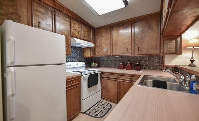 507 W Fawn St, Caldwell, TX 77836 - kitchen with white appliances, under cabinet range hood, light countertops, and decorative backsplash